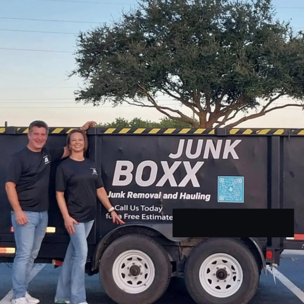 The Junk Boxx team beside their branded trailer